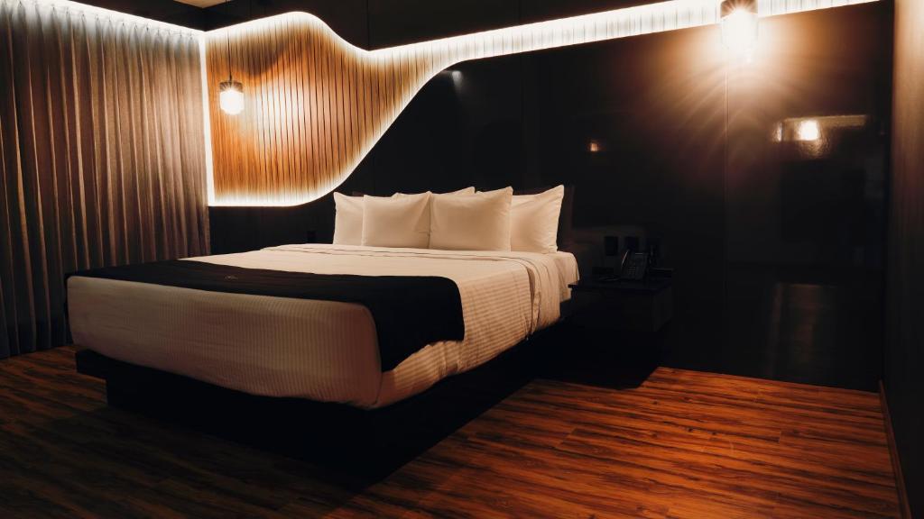 a bedroom with a large bed with lights on it at Hotel Yoru in Querétaro
