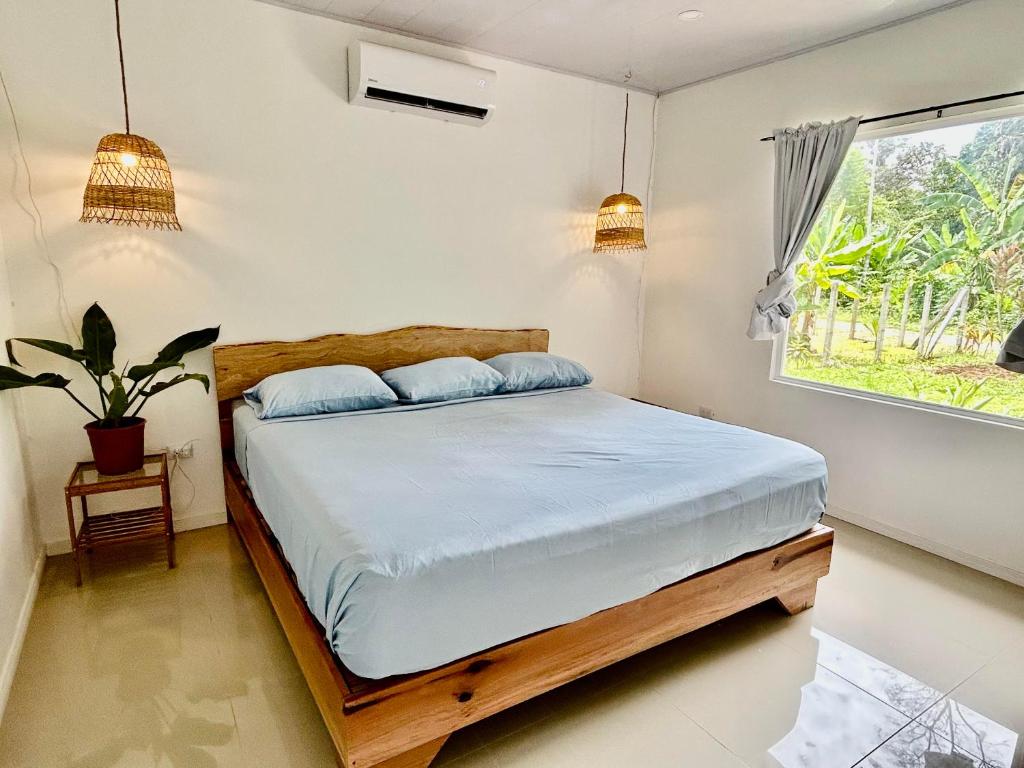 um quarto com uma cama e uma janela em Casa Martin Cahuita Charming Spanish Home em Cahuita