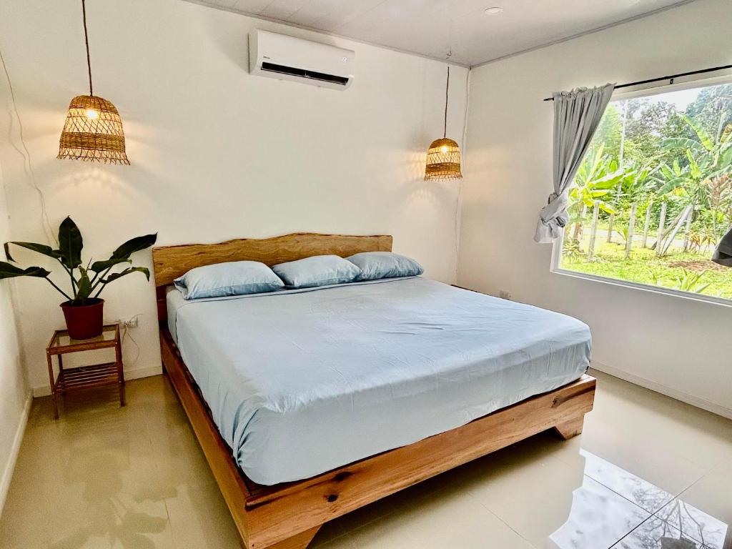 a bedroom with a bed and a window at Casa Martin Cahuita Charming Spanish Home in Cahuita