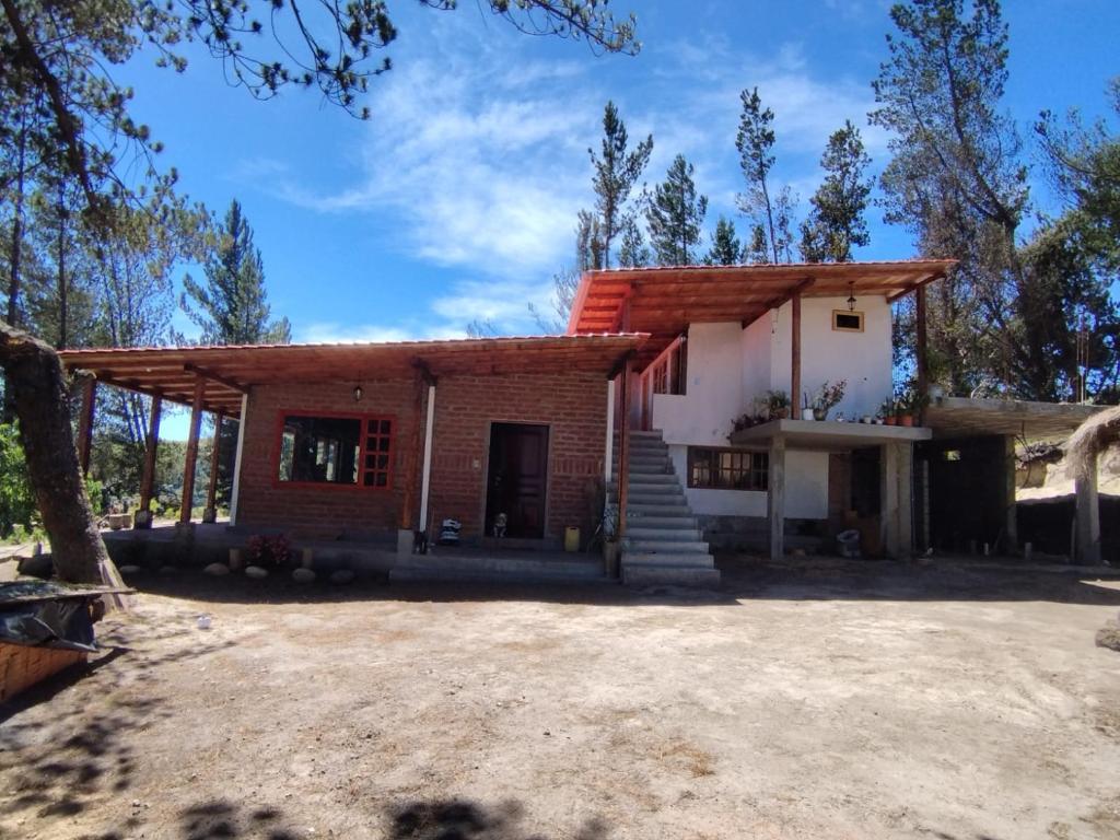 a small brick house with a red roof at Puyu Pacha Adventure in Sigchos