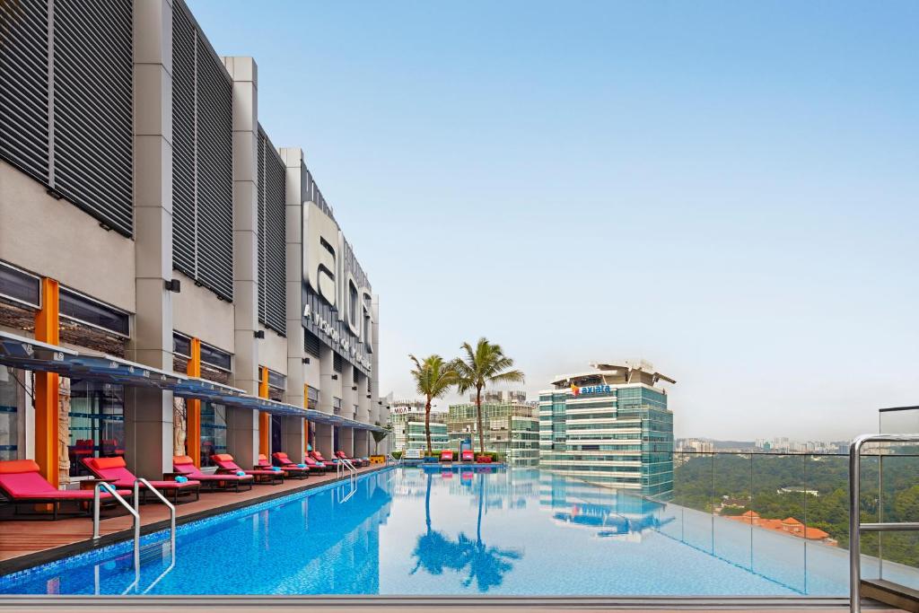 ein großer Pool in einem Gebäude mit Stühlen in der Unterkunft Aloft Kuala Lumpur Sentral in Kuala Lumpur