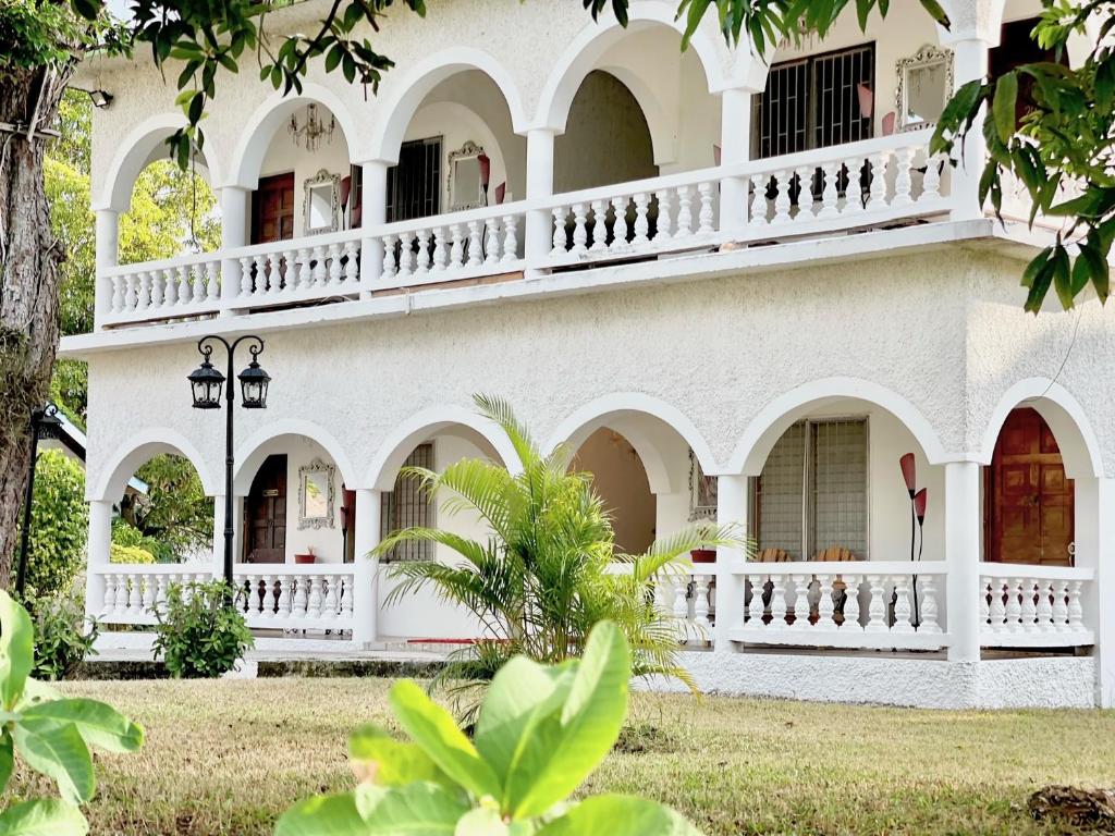 - un grand bâtiment blanc avec balcon dans l'établissement Summerset Residence Negril, à Negril