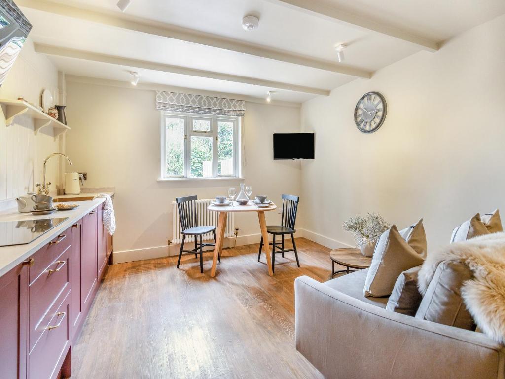 a kitchen and living room with a couch and a table at Llygad Y Dydd - Uk42788 in Bow Street