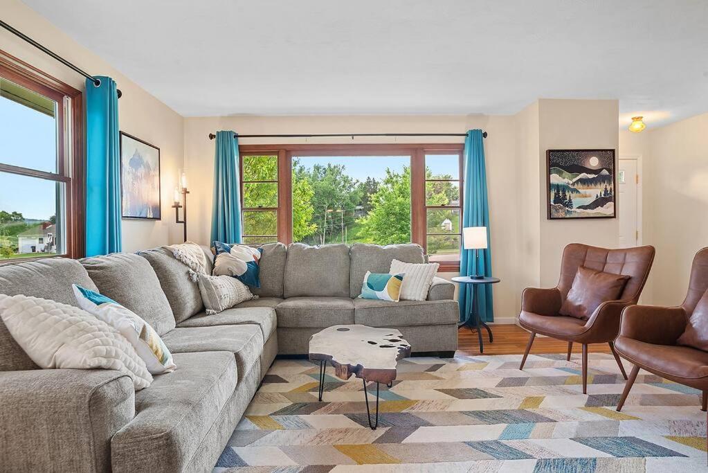 a living room with a gray couch and chairs at Mid-Century Magic - HUGE Space in Rapid City