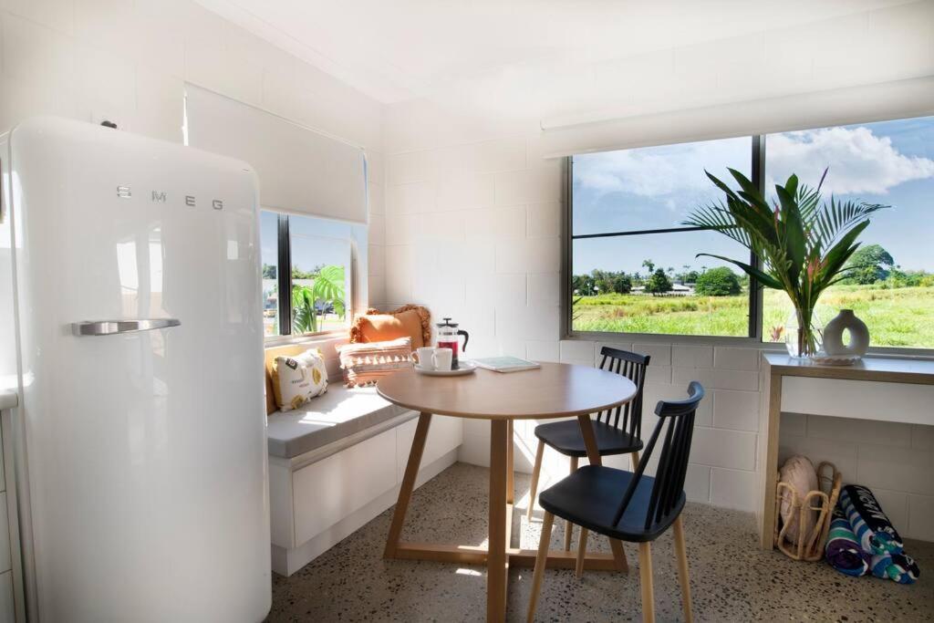 a kitchen with a table and chairs and a window at Iona Mission Beach- Stroll to shops cafes & beach in Mission Beach