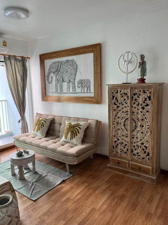 een woonkamer met een bank en een foto van een olifant bij Bohemian Bali style in Hua Hin