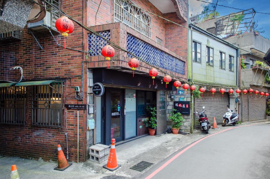 a building with red lanterns on the side of a street at Ju jiu House in Jiufen