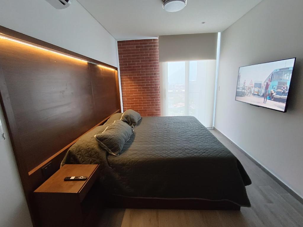 1 dormitorio con 1 cama grande y cabecero de madera en Departamento nuevo en Centro Cuauhtémoc, en Monterrey