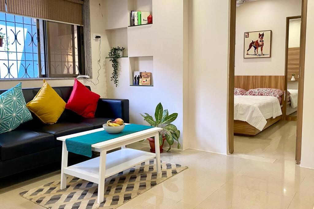 a living room with a couch and a table at Scarlett 102, Chapel Road by Connekt Homes in Mumbai