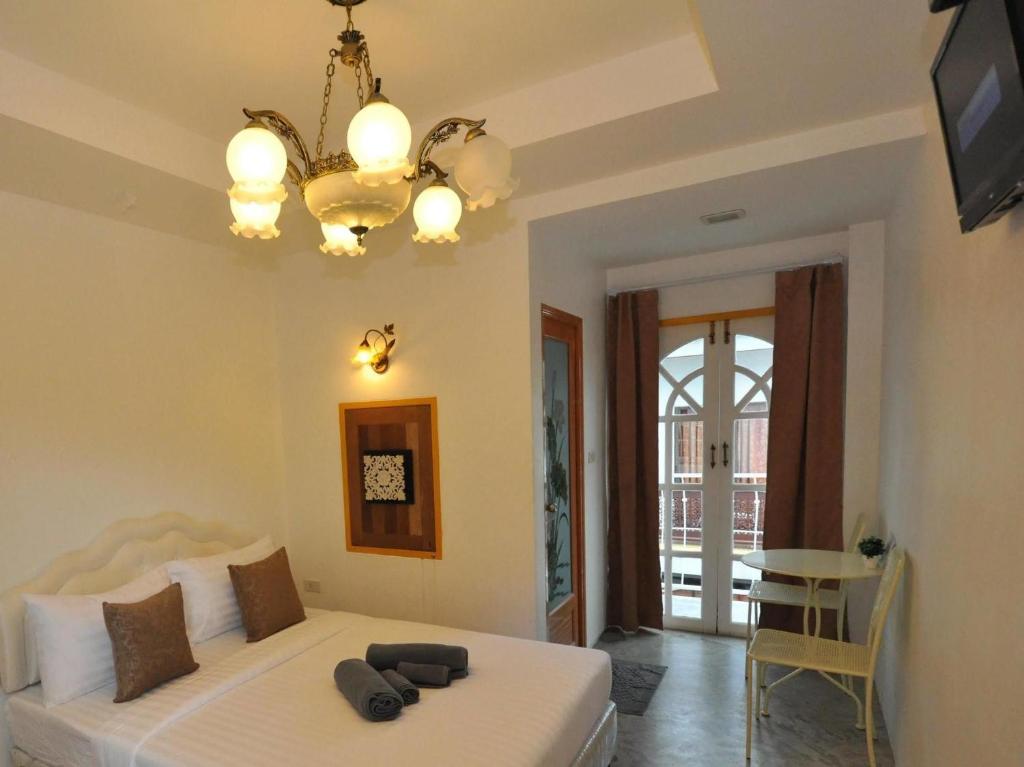 a bedroom with a bed and a chandelier at Sidewalk Boutique Hotel in Ko Samed