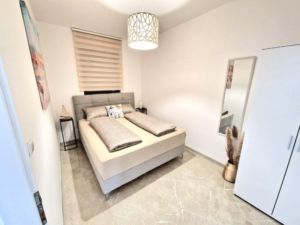 una camera con letto e specchio di Apartments Tadic a Omišalj (Castelmuschio)