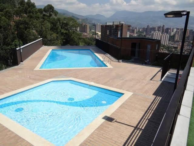 zwei Swimmingpools auf dem Dach eines Gebäudes in der Unterkunft Apartamento de lujo belen medellin. Piscina y gym in Medellín