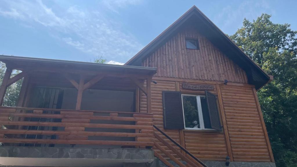 a log cabin with a porch and a window at Vila Vera Vrsac in Vršac