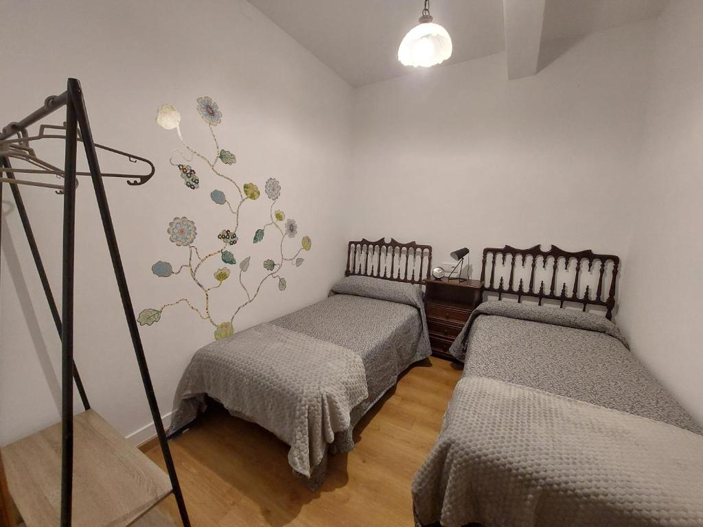 a room with two twin beds and a tripod at Casa Vily in Vilagarcia de Arousa