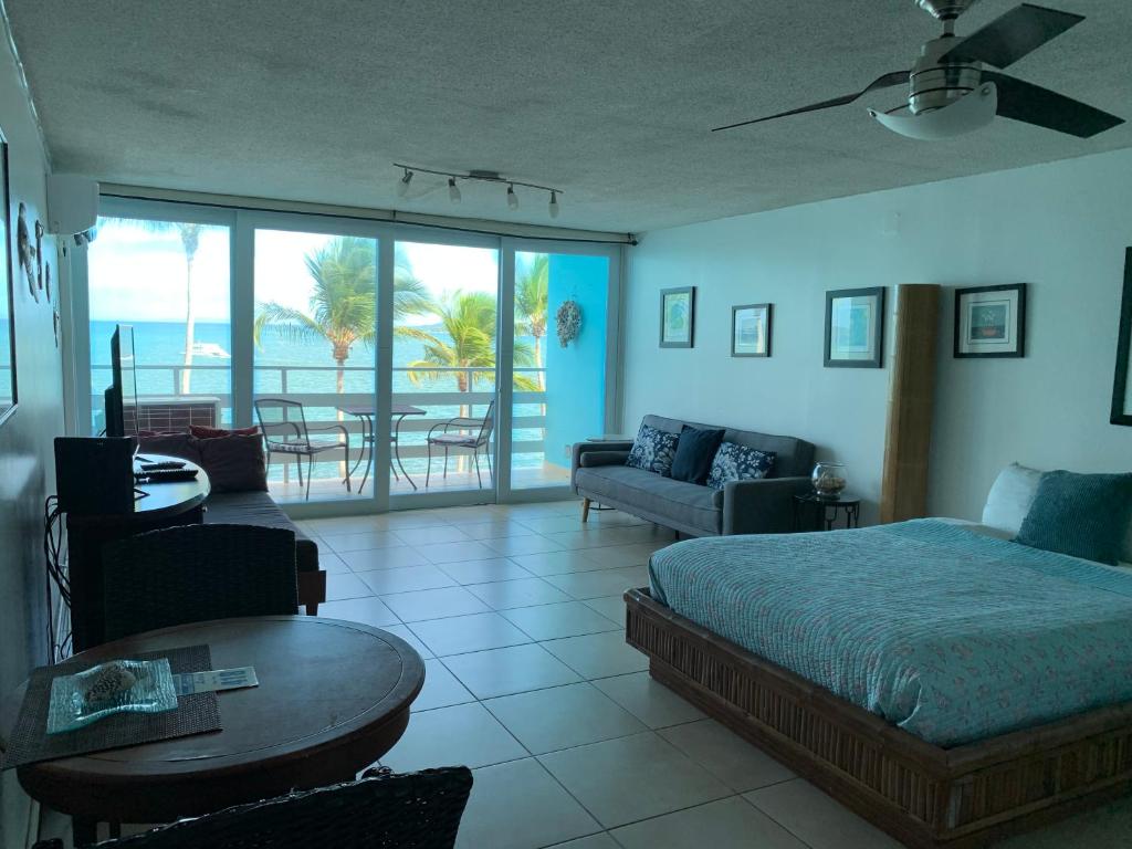 a bedroom with a bed and a living room at Cond. Marina Lanais in Fajardo