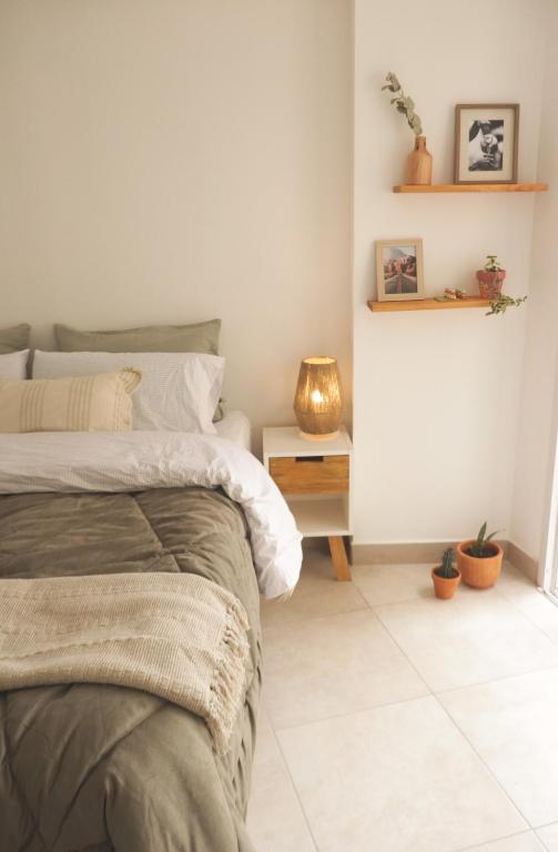 ein Schlafzimmer mit einem Bett und einem Tisch mit einer Lampe in der Unterkunft Casa Mate in Salta