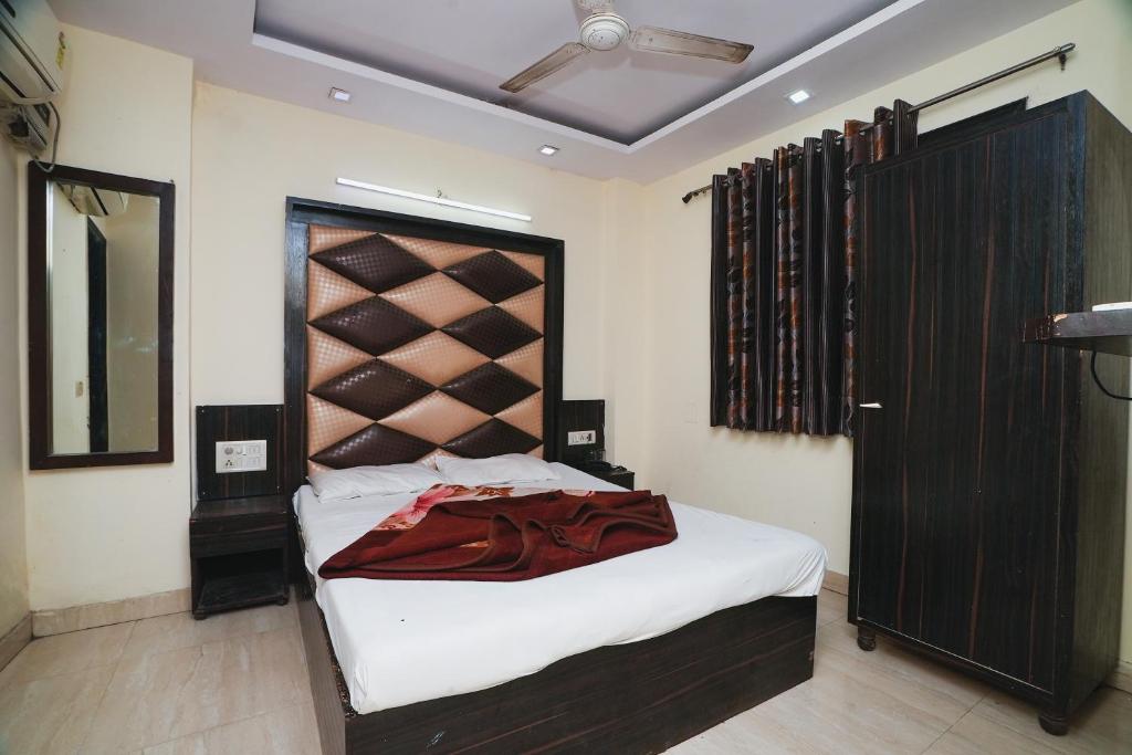a bedroom with a large bed with a wooden headboard at Hotel A V International in New Delhi