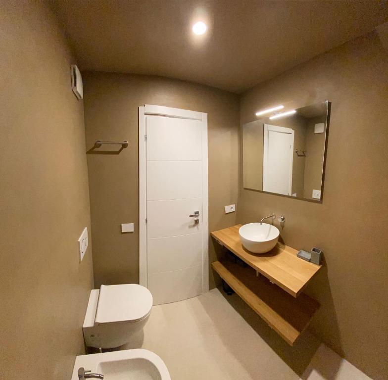 La salle de bains est pourvue de toilettes, d'un lavabo et d'un miroir. dans l'établissement Dahu Porto Cervo 2 camere 2 bagni sulla spiaggia, à Porto Cervo