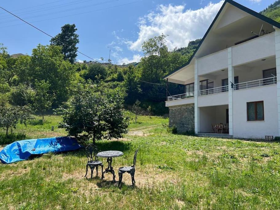 a house with two chairs and a table in a field at Machka Resort in Trabzon