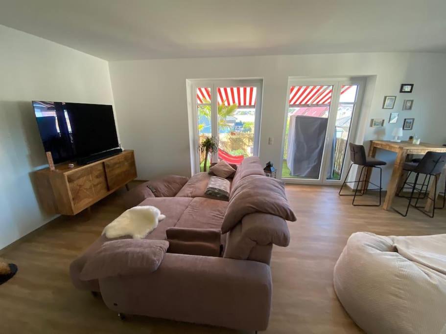 a living room with a large couch and a flat screen tv at Wunderbare Ferienwohnung mit Nähe zum Badesee in Goldenstedt