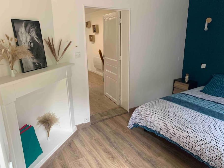 ein Schlafzimmer mit einem Bett und einen Flur mit einer Tür in der Unterkunft Charmante maison en duplex mitoyenne in Cransac