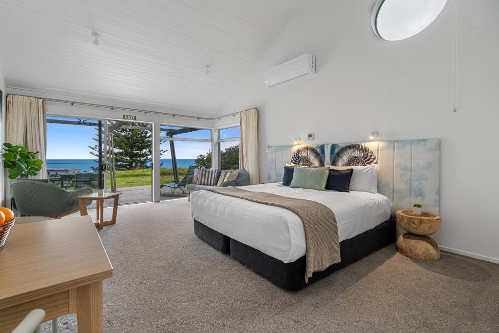 Schlafzimmer mit einem großen Bett und Meerblick in der Unterkunft Tasman Holiday Parks - Papamoa Beach in Papamoa