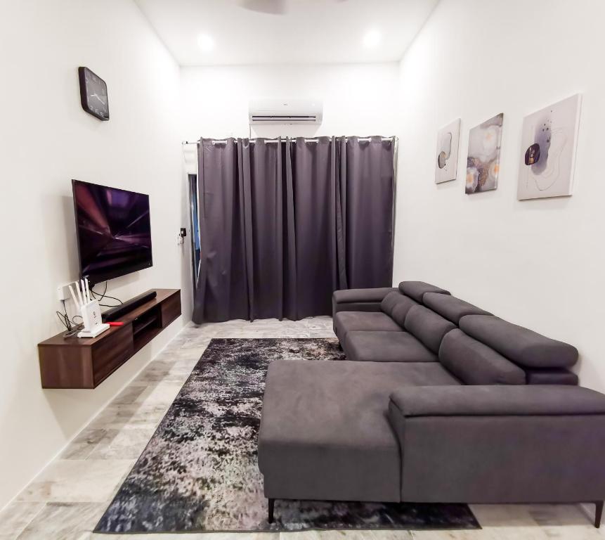 a living room with a couch and a television at SORANOS HOMESTAY TAMBUN in Ipoh