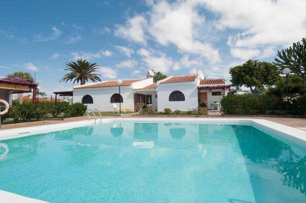 una grande piscina davanti a una casa di Maspalomas Suites a Maspalomas