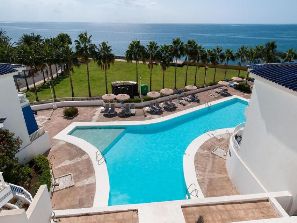 an overhead view of a swimming pool with the ocean in the background at Pasito Villas in Pasito Blanco