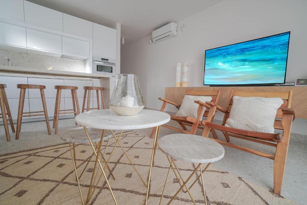 a living room with a table and chairs and a tv at Agustino Beach Suites San Agustin in San Agustin