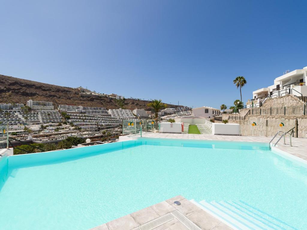 une grande piscine avec une montagne en arrière-plan dans l'établissement Cumana Suites Puerto Rico, à Puerto Rico