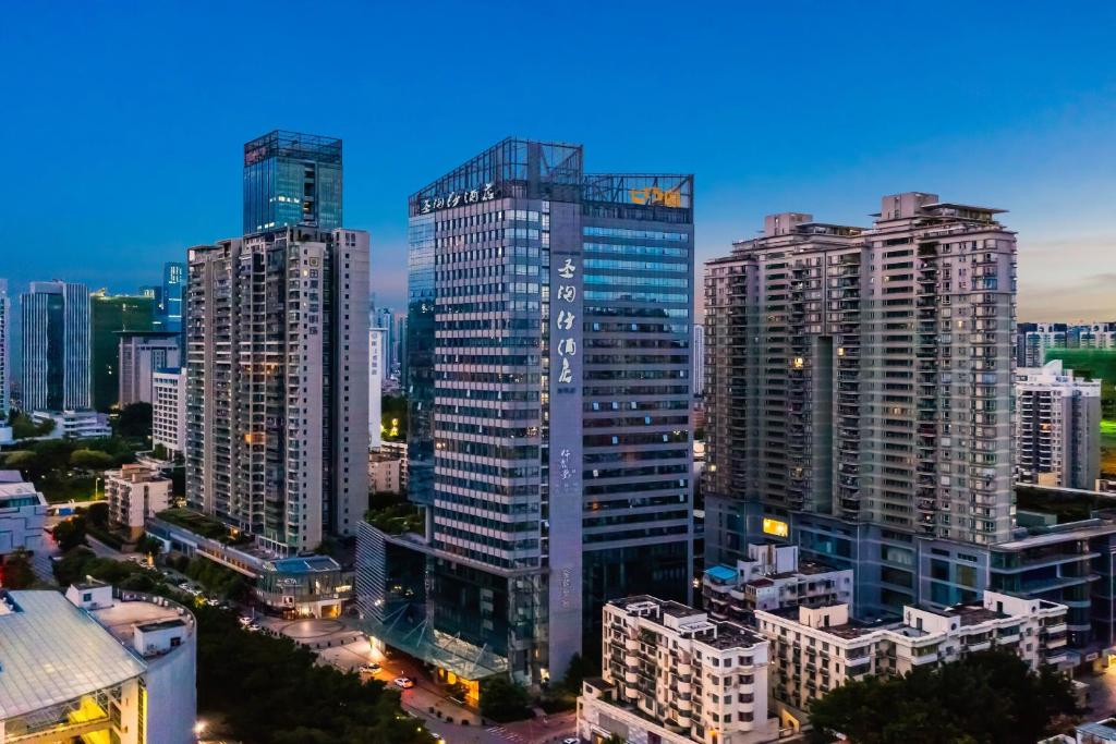 um horizonte da cidade com edifícios altos em uma cidade em Sentosa Hotel Shenzhen Feicui Branch, Enjoy tropical swimming pools and high-class fitness club em Shenzhen