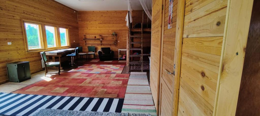 ein leeres Zimmer mit Holzwänden und einem Zimmer mit einem Tisch in der Unterkunft BB Polle - with the horse view in Mikkeli