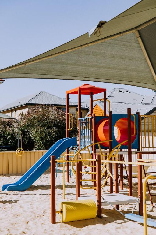 einen Spielplatz mit Rutsche im Sand in der Unterkunft The Jetty Resort in Esperance