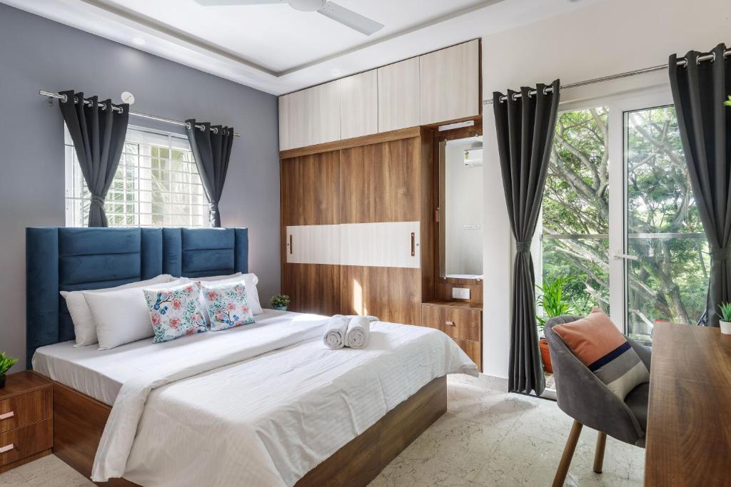 a bedroom with a large bed with a blue headboard at BluO Studios - Koramangala in Bengaluru