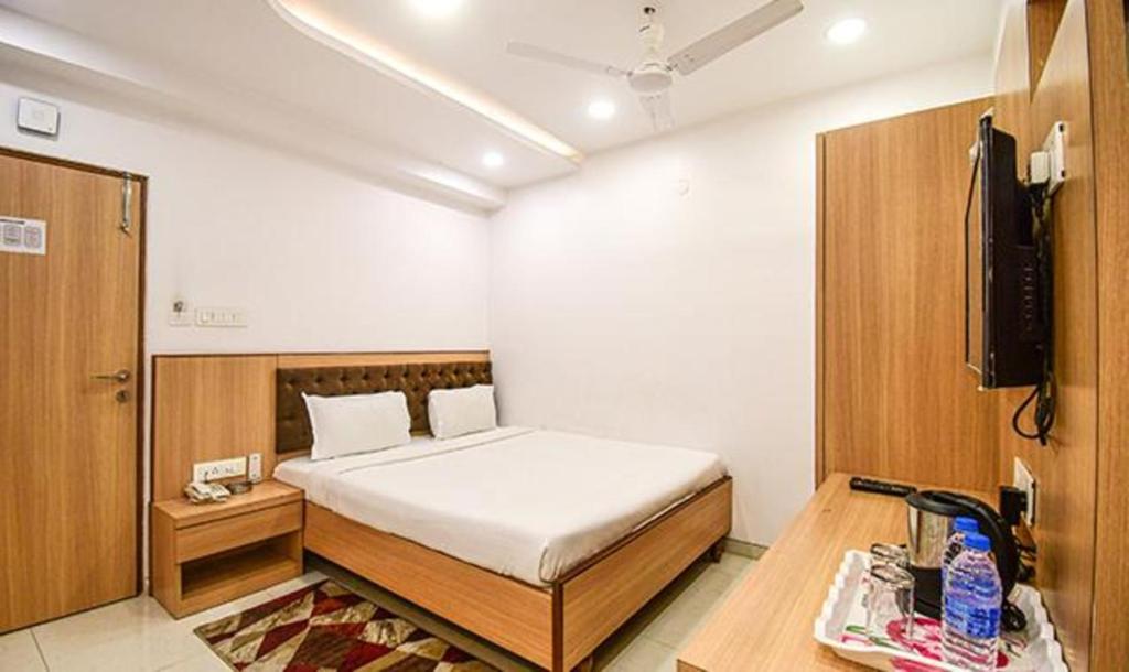 1 dormitorio con 1 cama y TV en FabHotel Stay Inn International, en Calcuta
