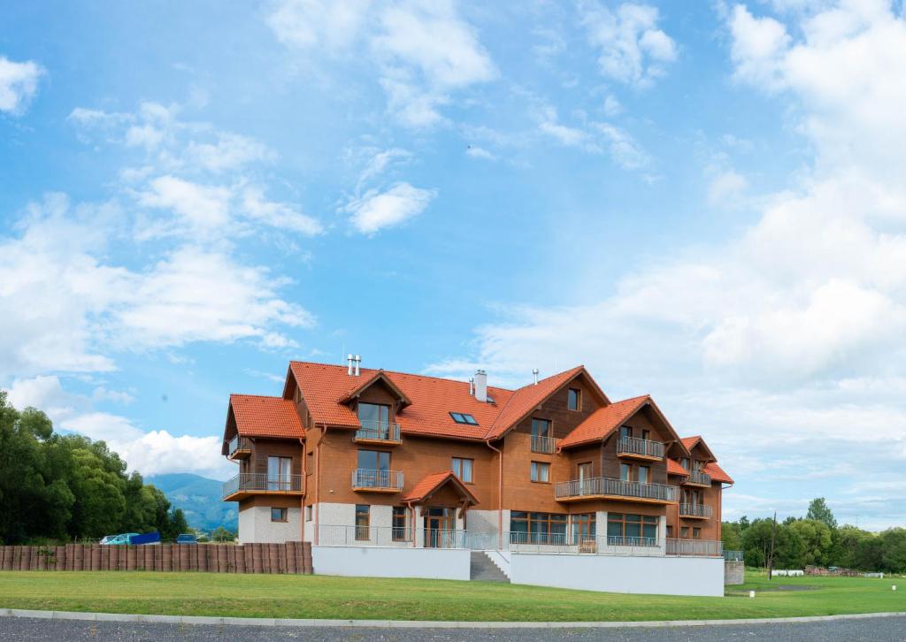 una casa con tetto arancione sul lato della strada di Penzion Kamence a Liptovský Mikuláš