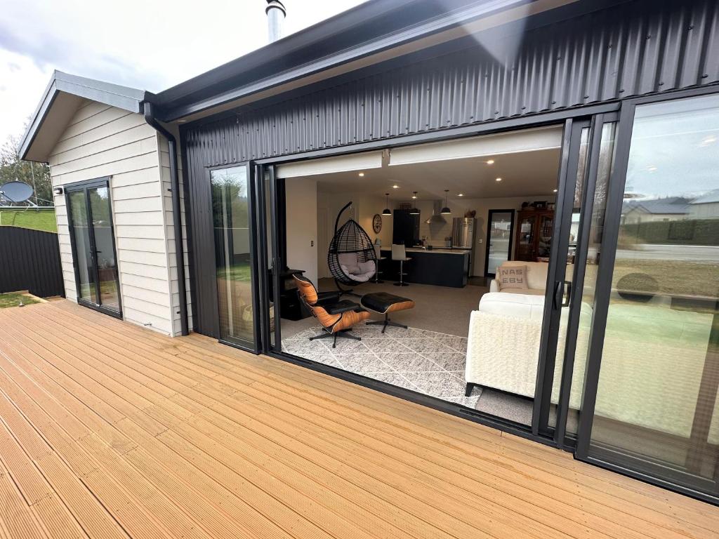 a large sliding glass door on a house with a deck at Naseby Modern Home in Naseby