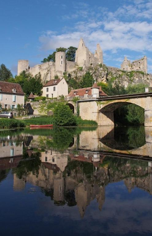 a bridge over a river with a castle in the background at Gite Bin Benaise sans linge in Pamproux