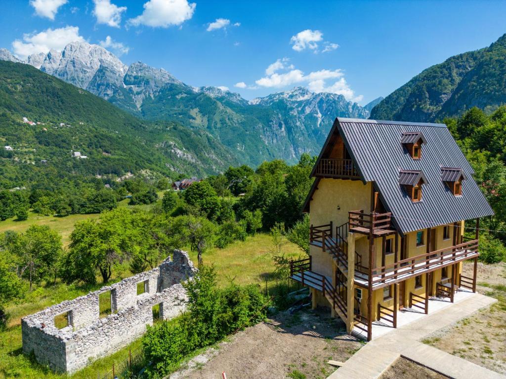 an image of a house with mountains in the background at Theth Kompleksi Gjoni in Theth