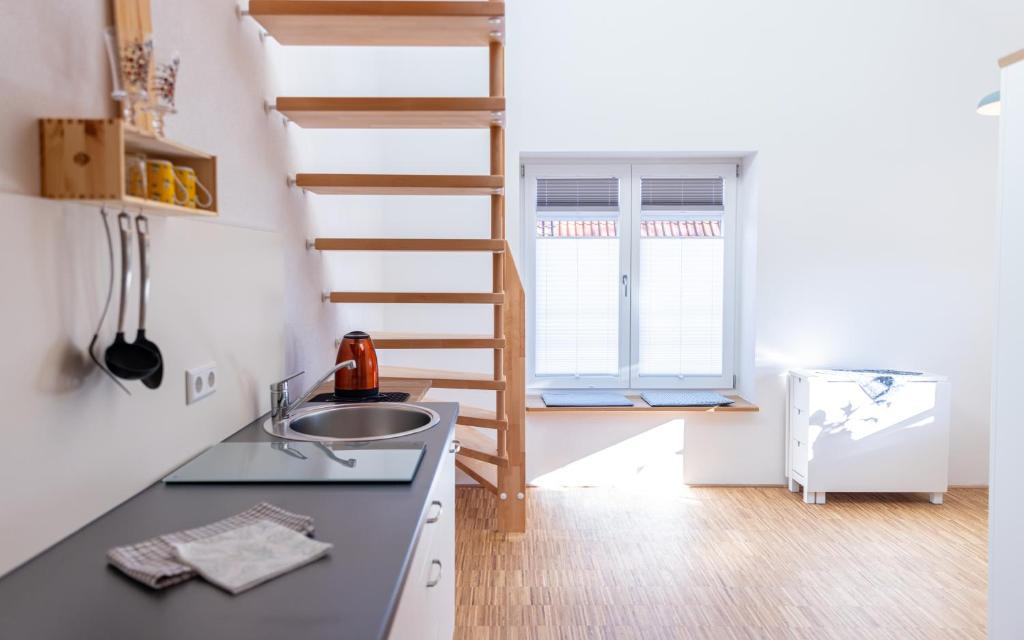 een keuken met een wastafel en een trap in een kamer bij Homely in Heidenheim an der Brenz