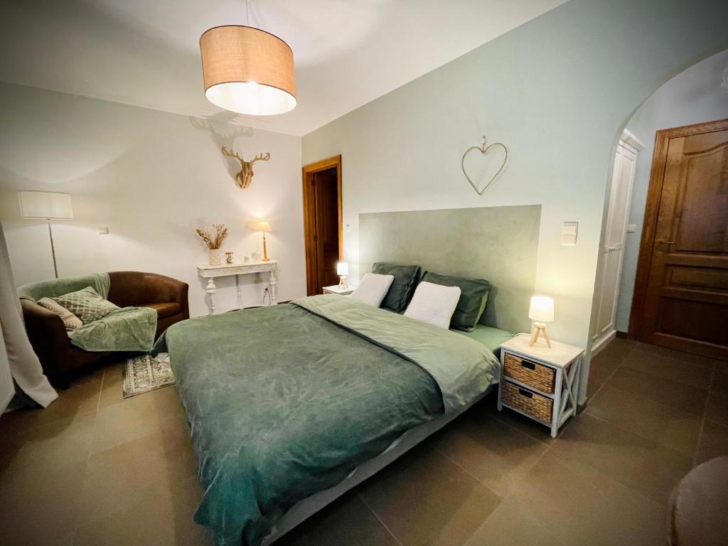 um quarto com uma cama grande e um sofá em La chambre d’auguste em Saint-Hubert