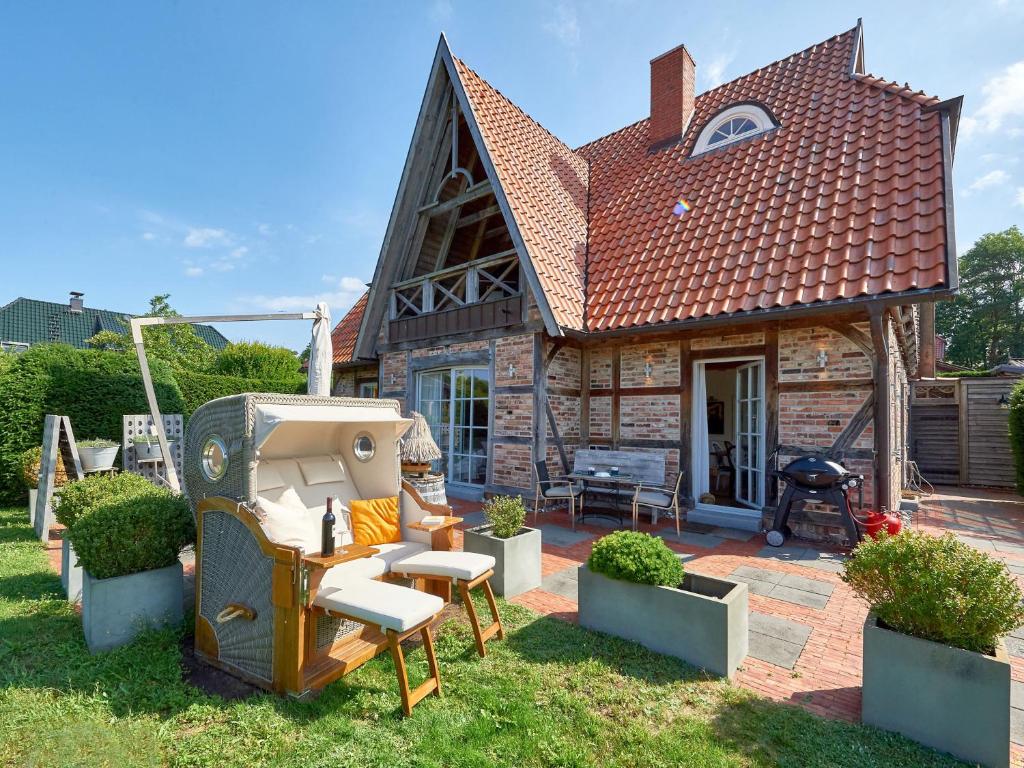 a small brick house with a grill and a backyard at Fachwerkhäuser Seedorf - Villa "Johanna Maria" mit Kamin, Sauna, Terrasse, Wasserblick in Sandort