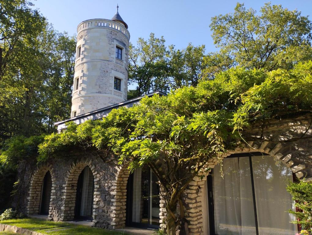 un bâtiment avec une tour en haut dans l'établissement Chambres d'hôtes La Tour de Bellevue, à Saumur