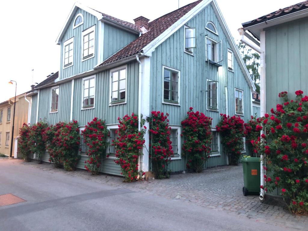 a blue house with flowers on the side of it at Vadstena semesterlägenhet in Vadstena