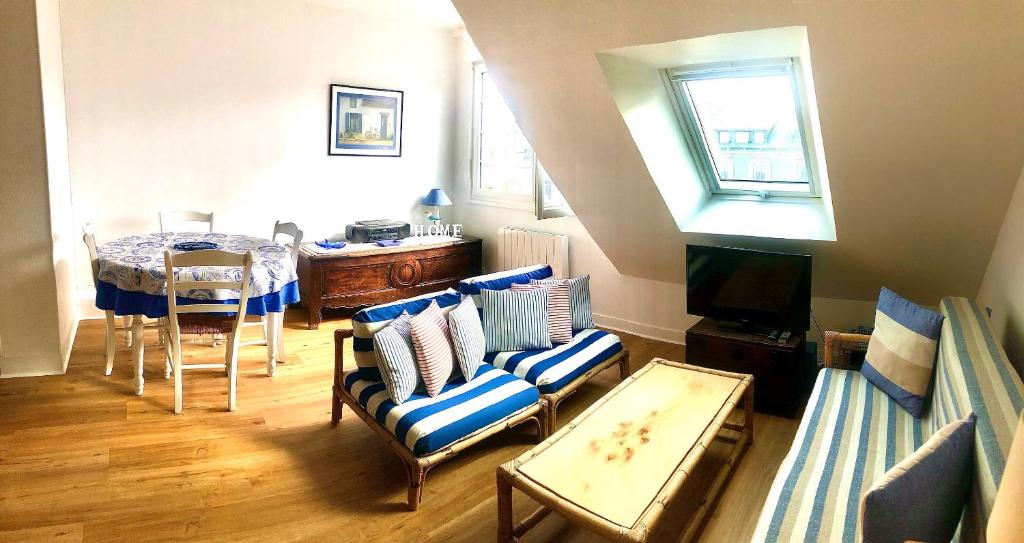 un salon avec un canapé et une table dans l'établissement L'Appartement de la Plage, à Saint-Quay-Portrieux