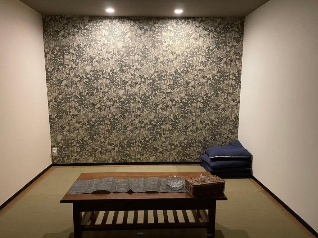 a room with a table in front of a wall at ABC accommodation in Osaka