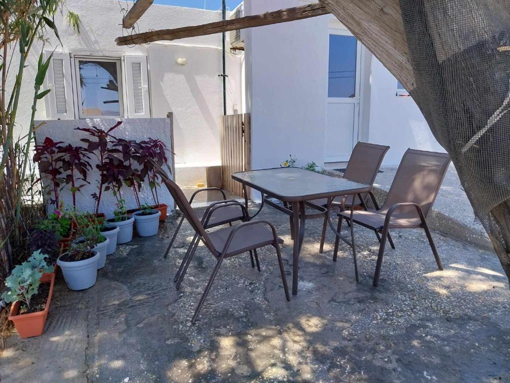 stół i krzesła na patio z roślinami w obiekcie SUMMER ESCAPE studios w mieście Parasporos