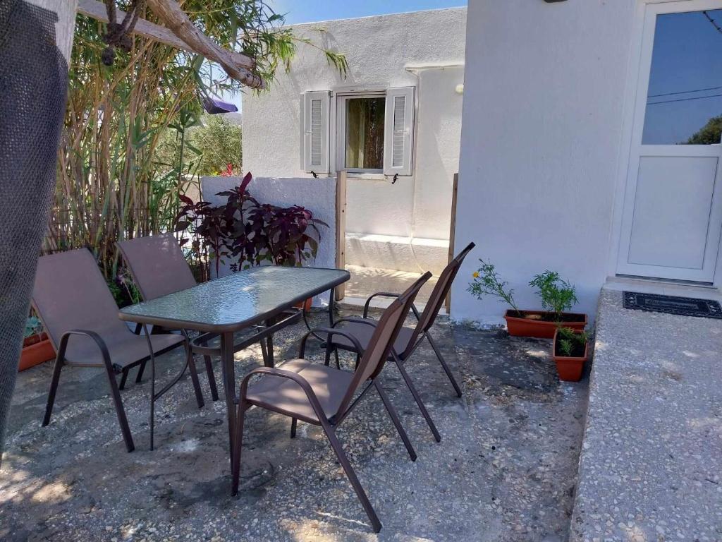 une table et des chaises devant une maison dans l'établissement SOUVLIA BEACH, à Parasporos
