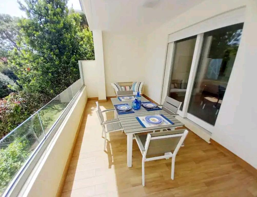 una sala da pranzo con tavolo e sedie sul balcone di Luxury home near the Beach private parking space ad Alghero